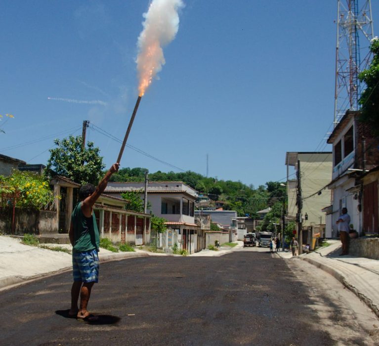 Moradores comemoram a chegada do asfalto com fogos de artifício em rua do Nova Belém